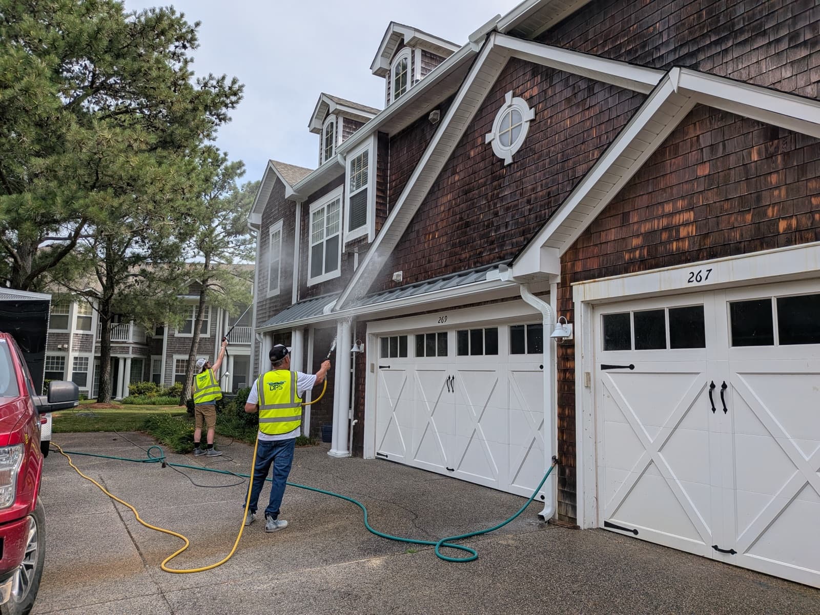 A Drone Precision Solutions crew soft-washing cedar-shake townhomes